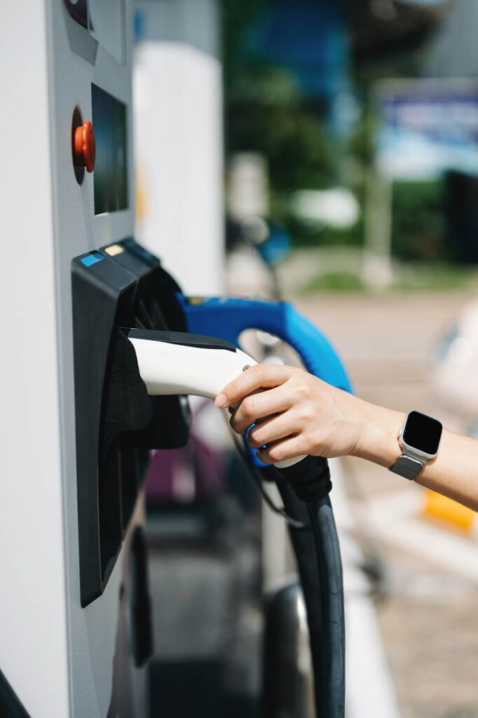 Hand plugging in a charger in an electric car socket.Electric ca