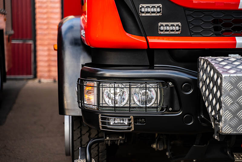 Cropped view of the big red fire engine standing at the garage. Red fire engine, emergency rescue truck with flasher siren light